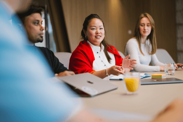 Diverse group of professionals engaged in a collaborative meeting around a conference table.